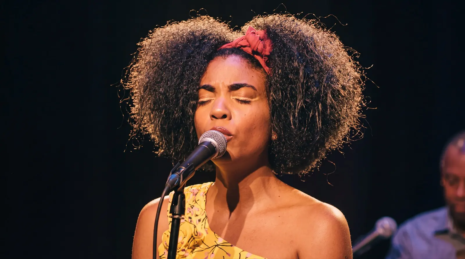 Yohana Peña singing live on stage with her eyes closed
